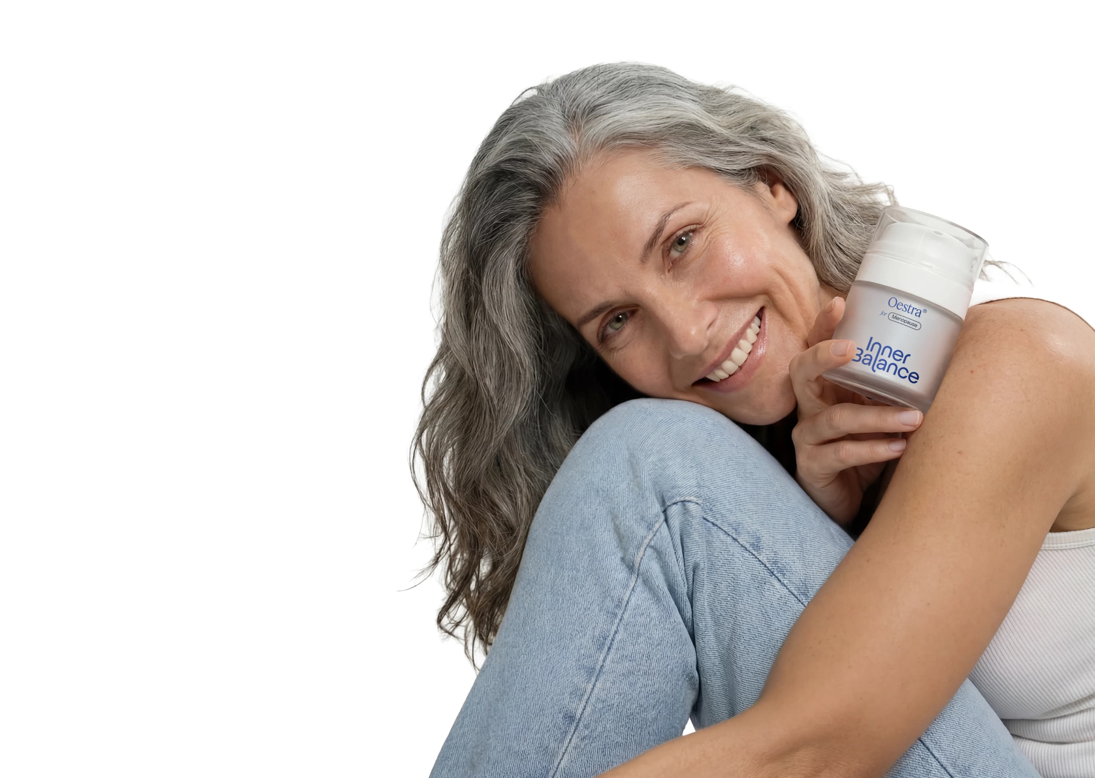 Woman smiling while holding Oestra menopause cream jar
